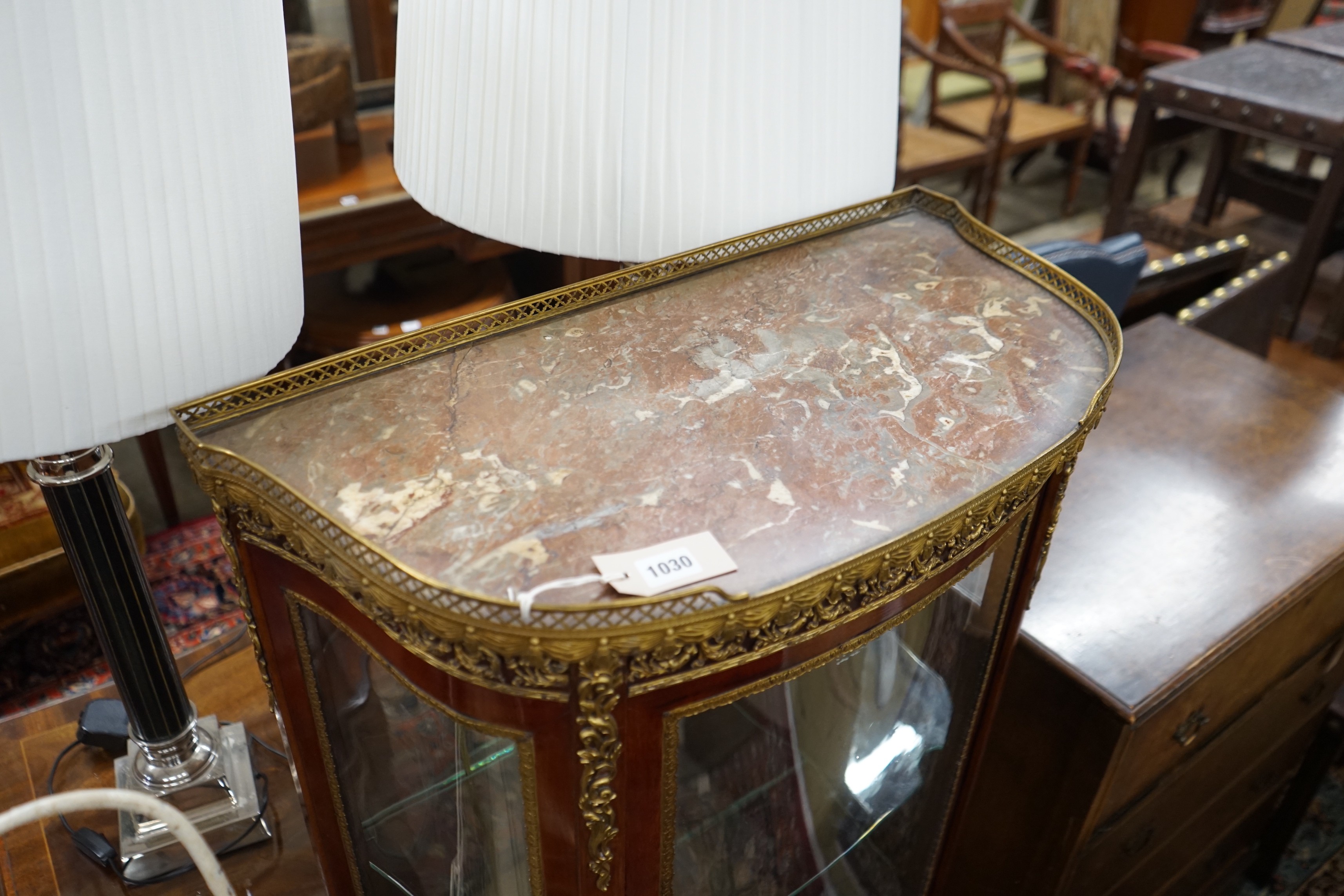 A Louis XV style gilt metal mounted marble topped bow fronted vitrine, width 67cm, depth 34cm, height 139cm